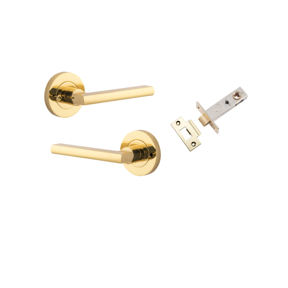 Pair of Iver Baltimore lever handles on round rose, finished in polished brass, shown on a door with keyhole cutouts.