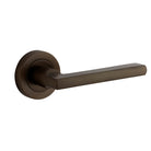 Pair of Iver Baltimore lever handles on round rose plates, featuring a sleek, modern design for door hardware.