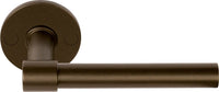 Pair of Formani ONE XL 15Ø lever handles on round rose, showcasing modern brass door hardware design.
