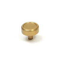 Momo Monaco cabinet knob in black with a sleek, rounded design, mounted on a wooden cabinet door.
