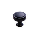 Momo PELLARO cabinet knob in matte black with rounded design, mounted on a wooden cabinet door.