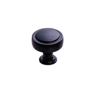 Momo PELLARO cabinet knob in matte black with rounded design, mounted on a wooden cabinet door.