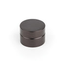 Momo POINT cabinet knob in textured black finish, featuring modern geometric design, mounted on a wooden cabinet door.