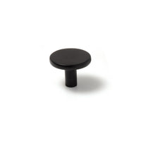 Momo VENA cabinet knob in matte black finish, round metal handle with sleek modern design, mounted on cabinet door.